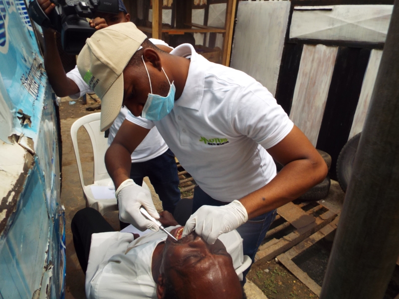 Dr. Toyin Adebale (Dental Surgeon) of Motus Health Initiative performing an extraction at a medical outreach done in conjuction with AJOWA CDA